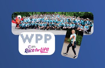 Large group of people in blue shirts at Race for Life charity event.